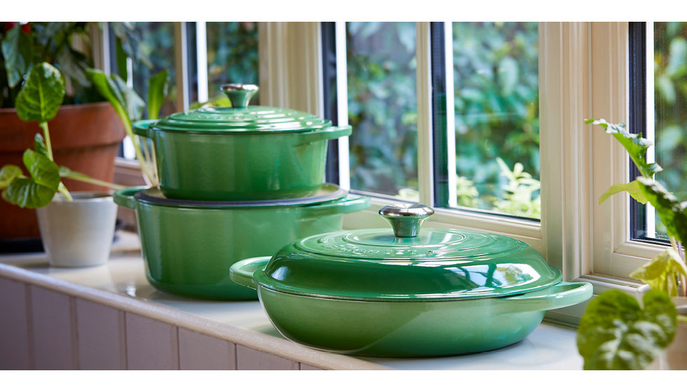 Rosemary coloured cast iron Le Creuset casserole dishes on a window sill in a home.