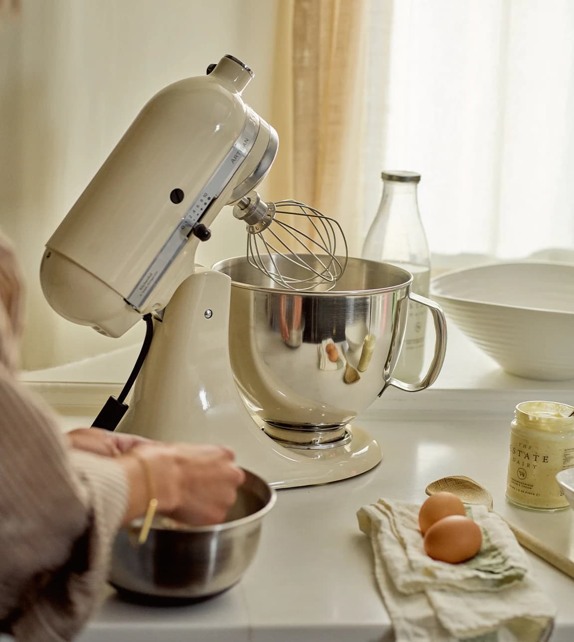 KitchenAid mixer in Almond Cream on a white kitchen worktop