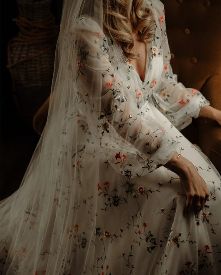 Bride sitting wearing her Sassi Holford wedding dress and a long veil