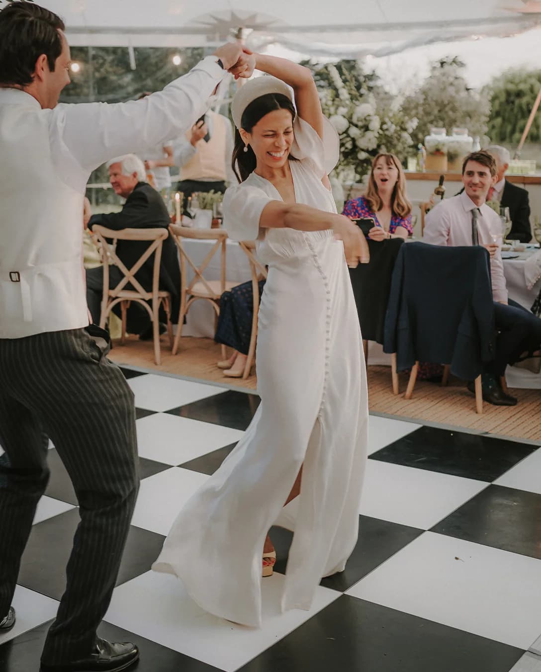 The bride and groom do their first dance on a dance floor in a marquee.