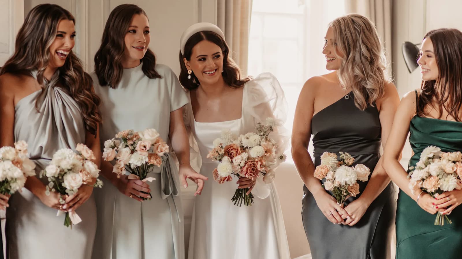 Bride and bridesmaids pose with serene autumn wedding bouquets