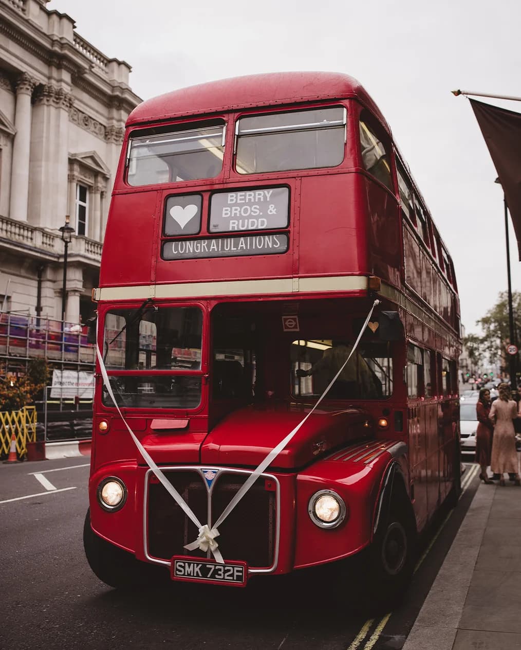 London red double-decker bus hired for wedding with custom congratulations sign and ribbons