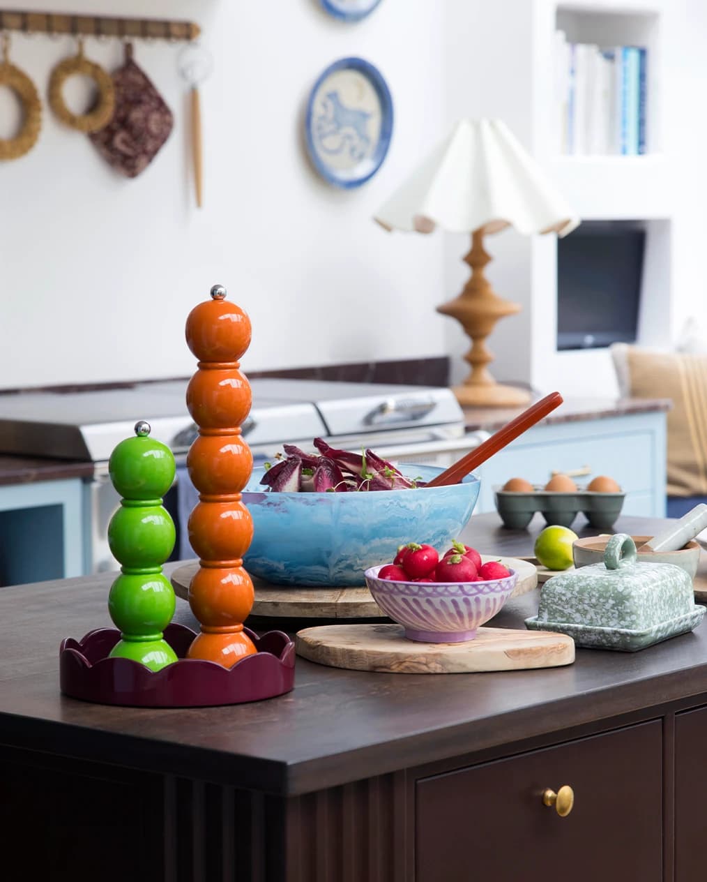 Colourful Addison Ross pepper mills are placed on a kitchen counter.