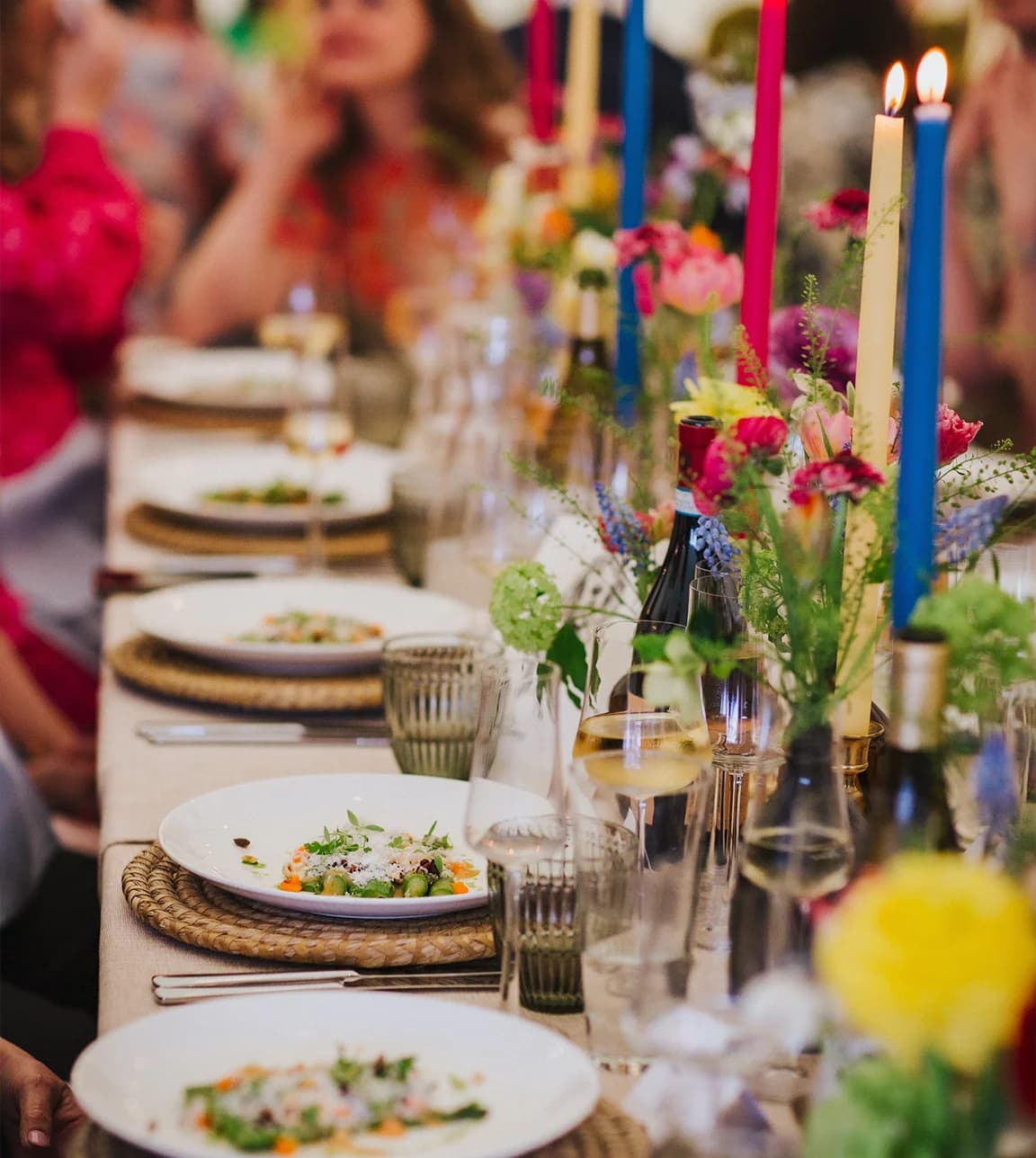 Wedding reception guests enjoy wedding catering with plated food, placed on beautifully decorated table.
