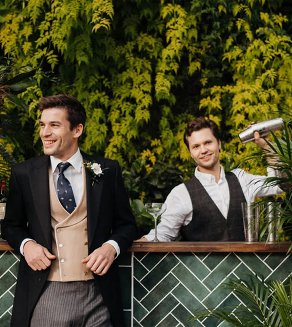 Groom stands next to a wedding bar