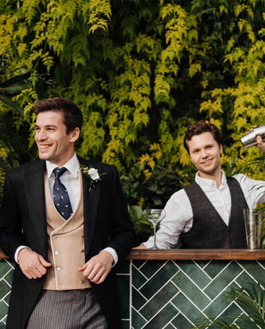 Groom stands next to a wedding bar