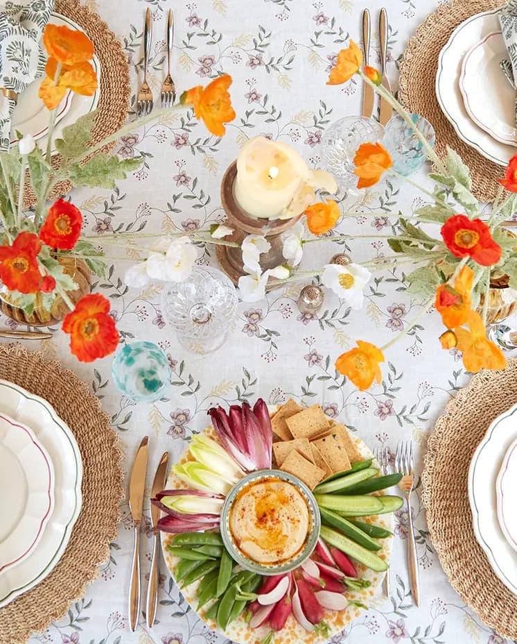 Summer tablescape with red poppies and floral tablecloth features food being served on luxury tableware & glassware wedding presents.