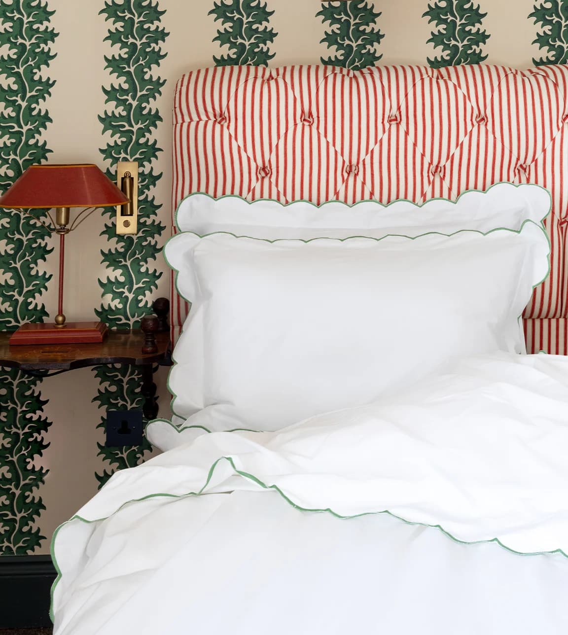 Stylish green bedroom with upholstered bed set with scalloped bed linen gifts from Rebecca Udall