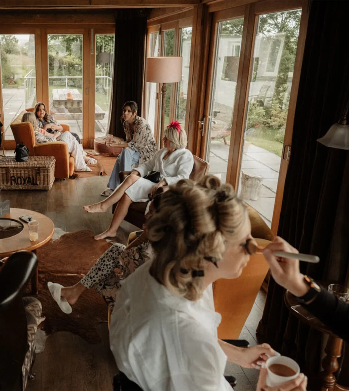 Bridal party with the bride while she gets her hair and makeup done by a makeup artist