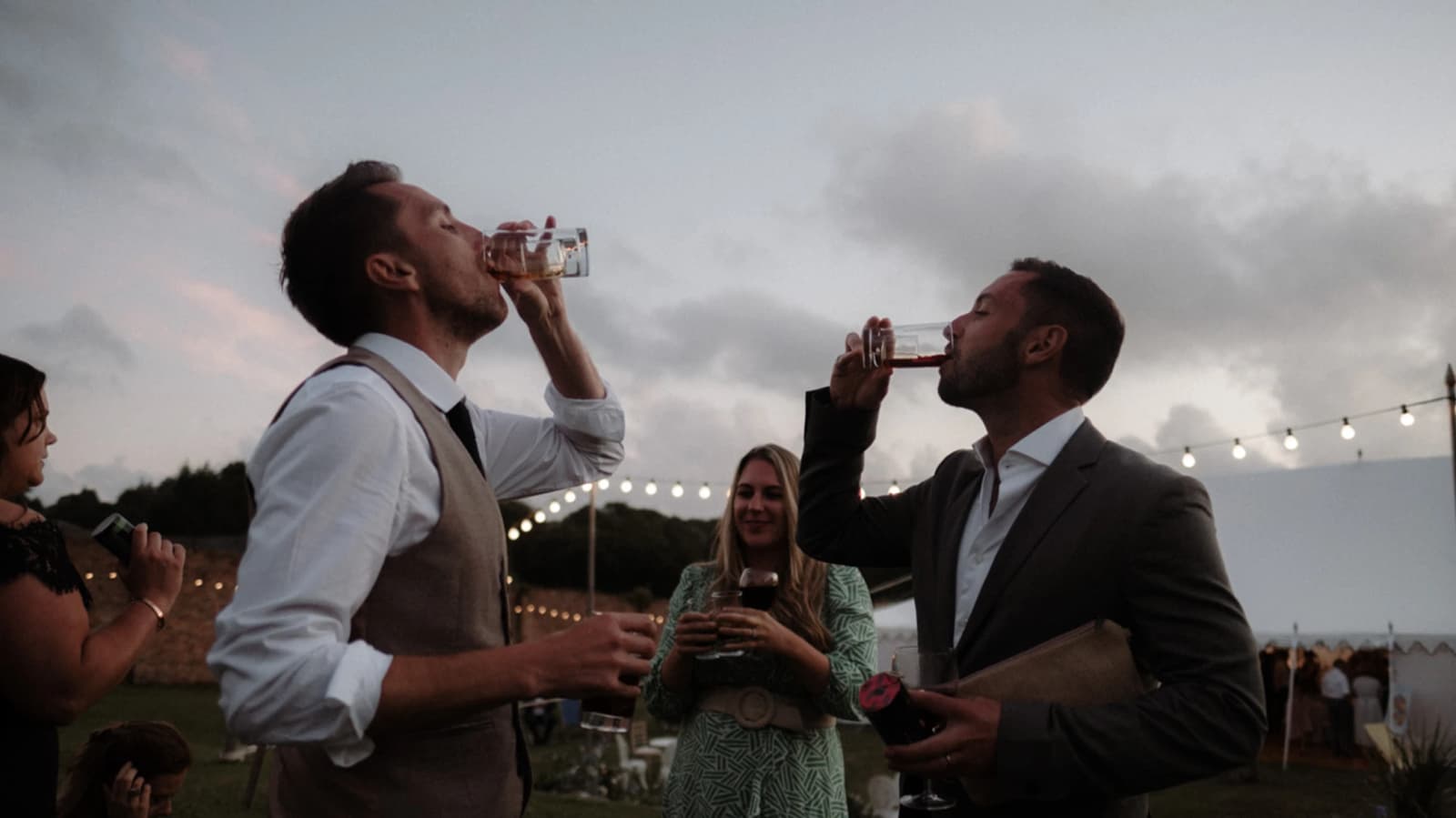 Wedding guests drinking outside the marquee at this festival-inspired Cornwall wedding