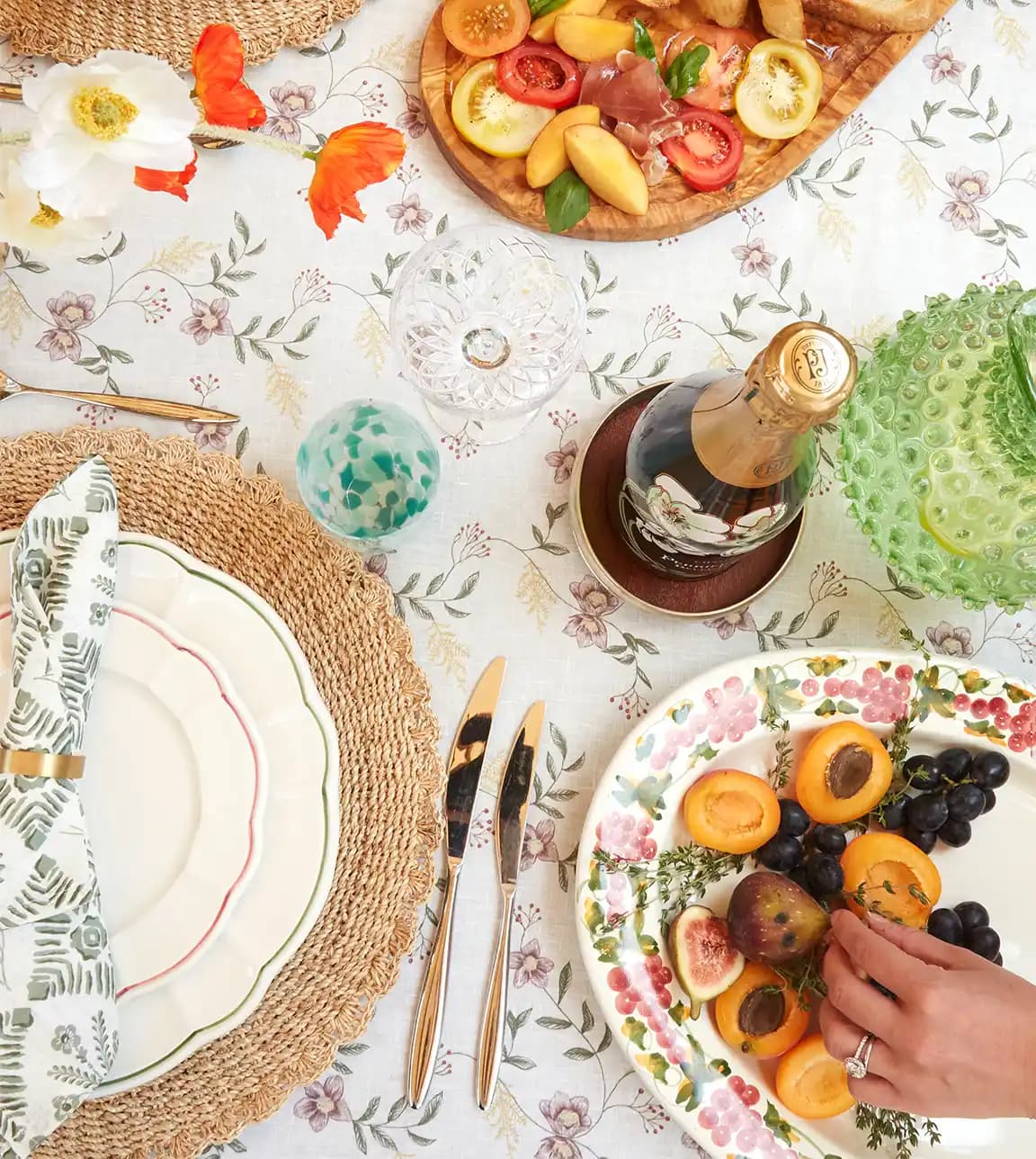 Summer tablescape on floral tablecloth serves food on luxury tableware & glassware wedding presents.