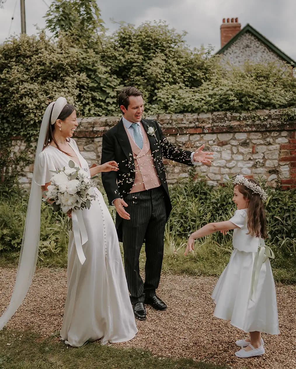 bride and groom with their cute flower girl cute moment