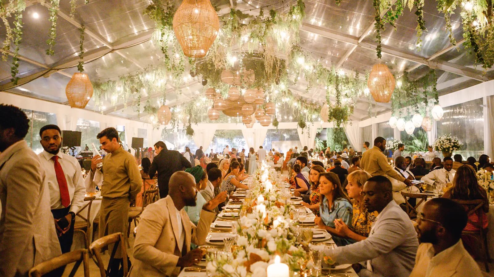 Wedding guests chat to each other during wedding dinner in a luxury tent