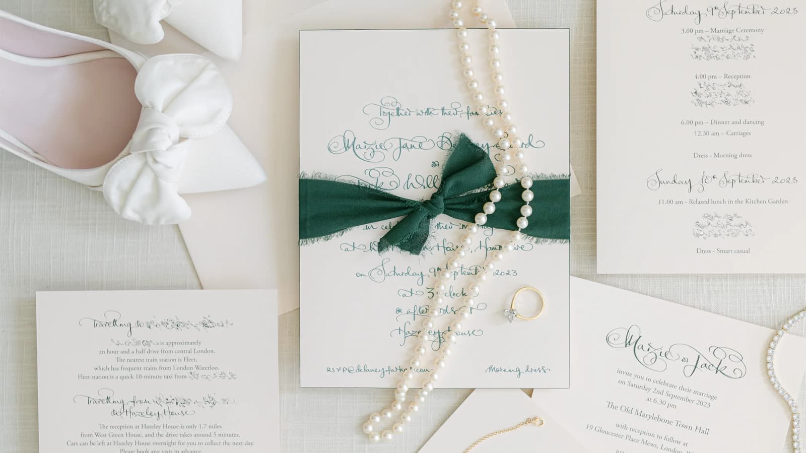 Handwritten wedding invites and wedding stationery are tastefully arranged next to bride's shoe and jewellery