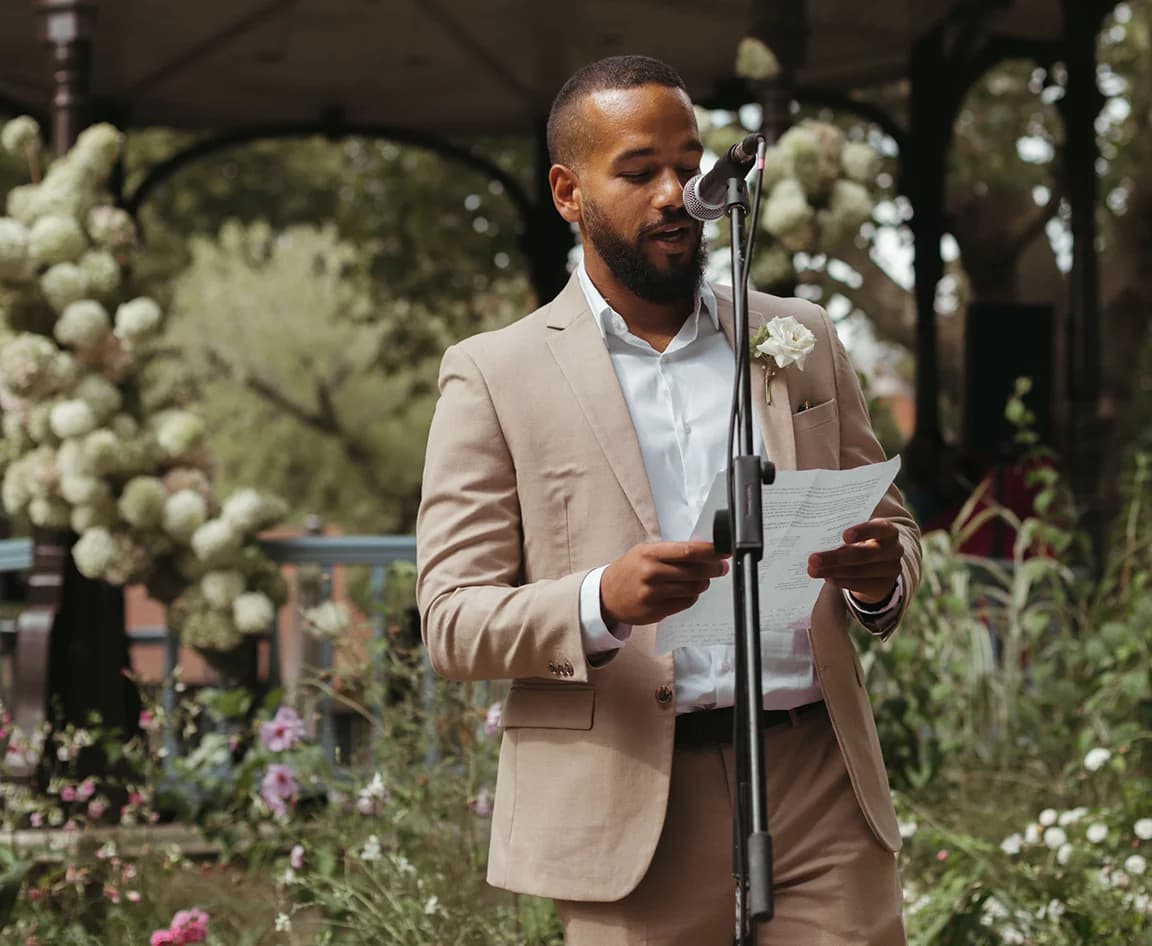 A man gives wedding reading during a wedding in park