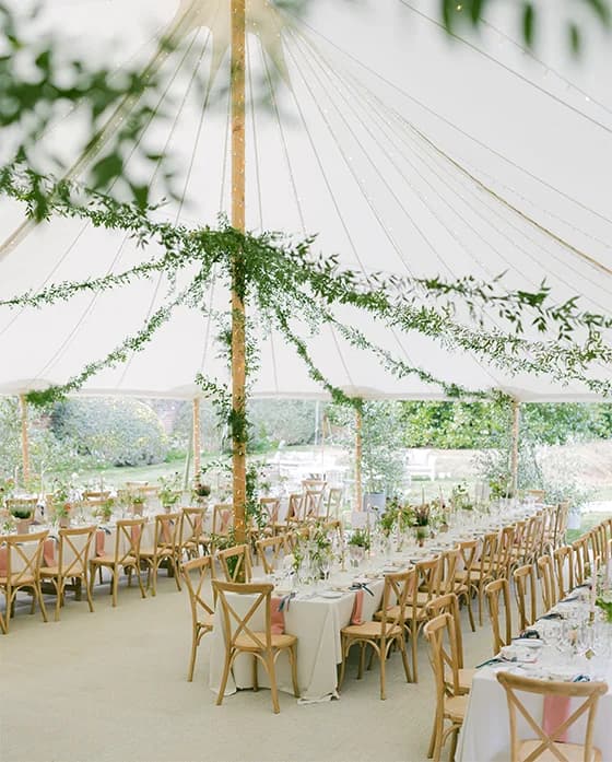 Inside of the traditional wedding marquee with garden-themed decor.