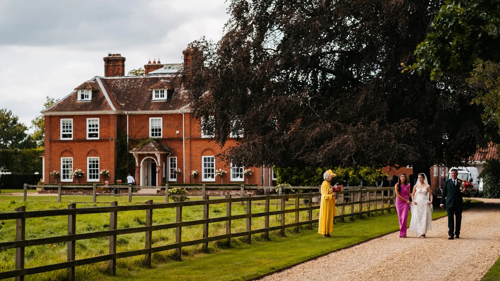 Bride walks from the wedding venue, a Georgian manor house in the countryside