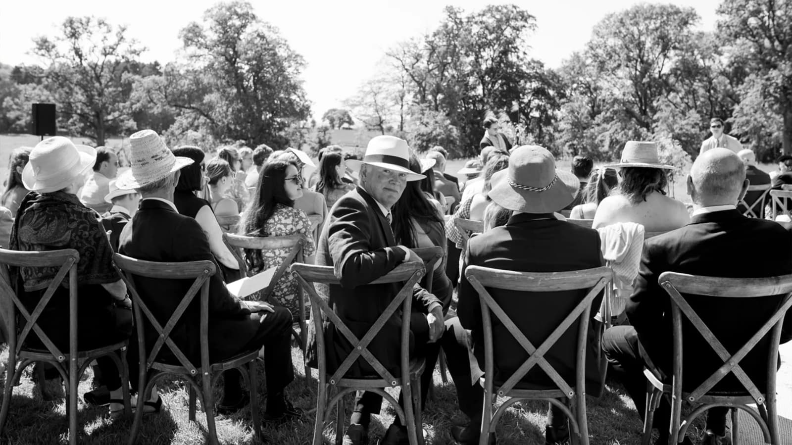 One of the wedding guests is turning towards the camera during wedding ceremony