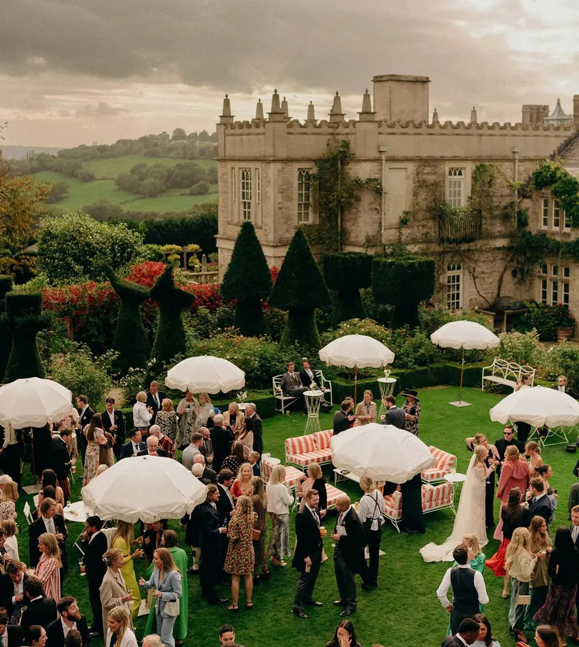 Guests enjoy the wedding reception at English castle gardens.