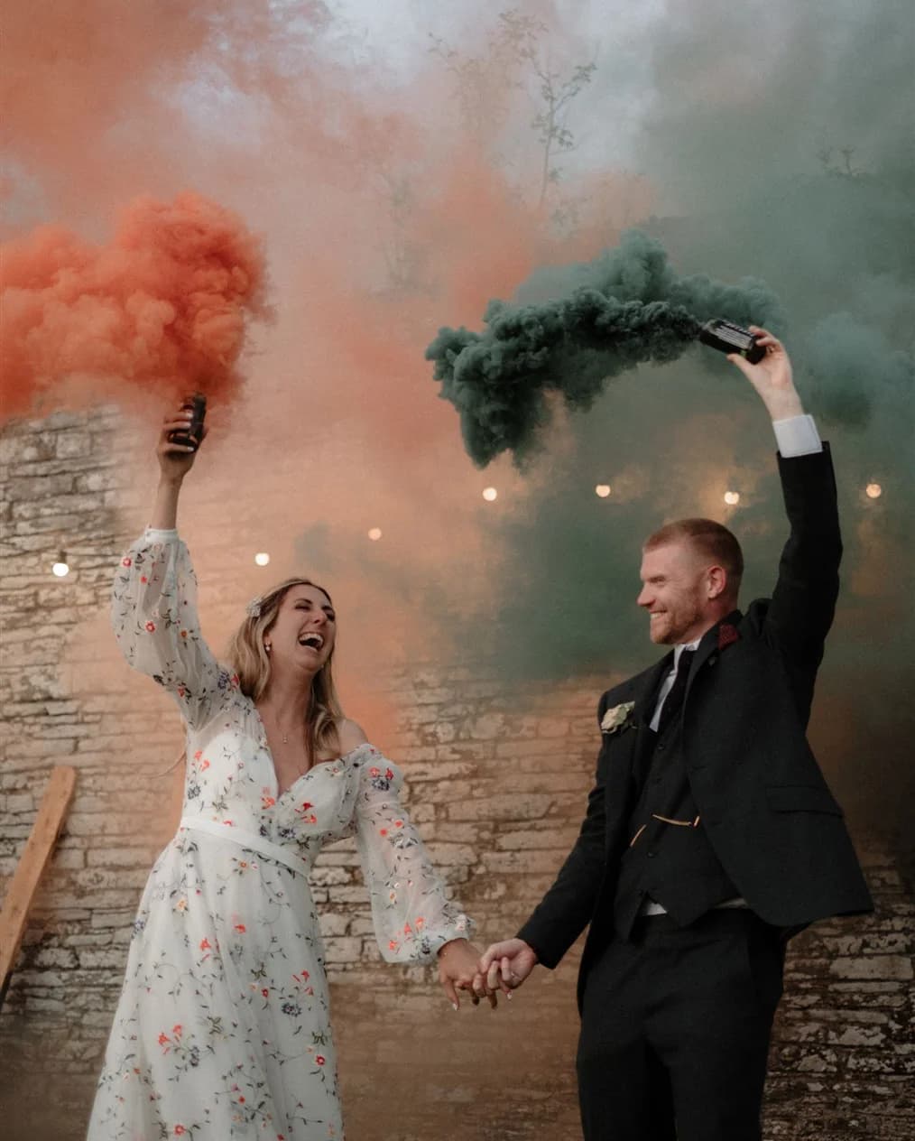 Bride and groom setting off colourful flares at their Cornwall wedding