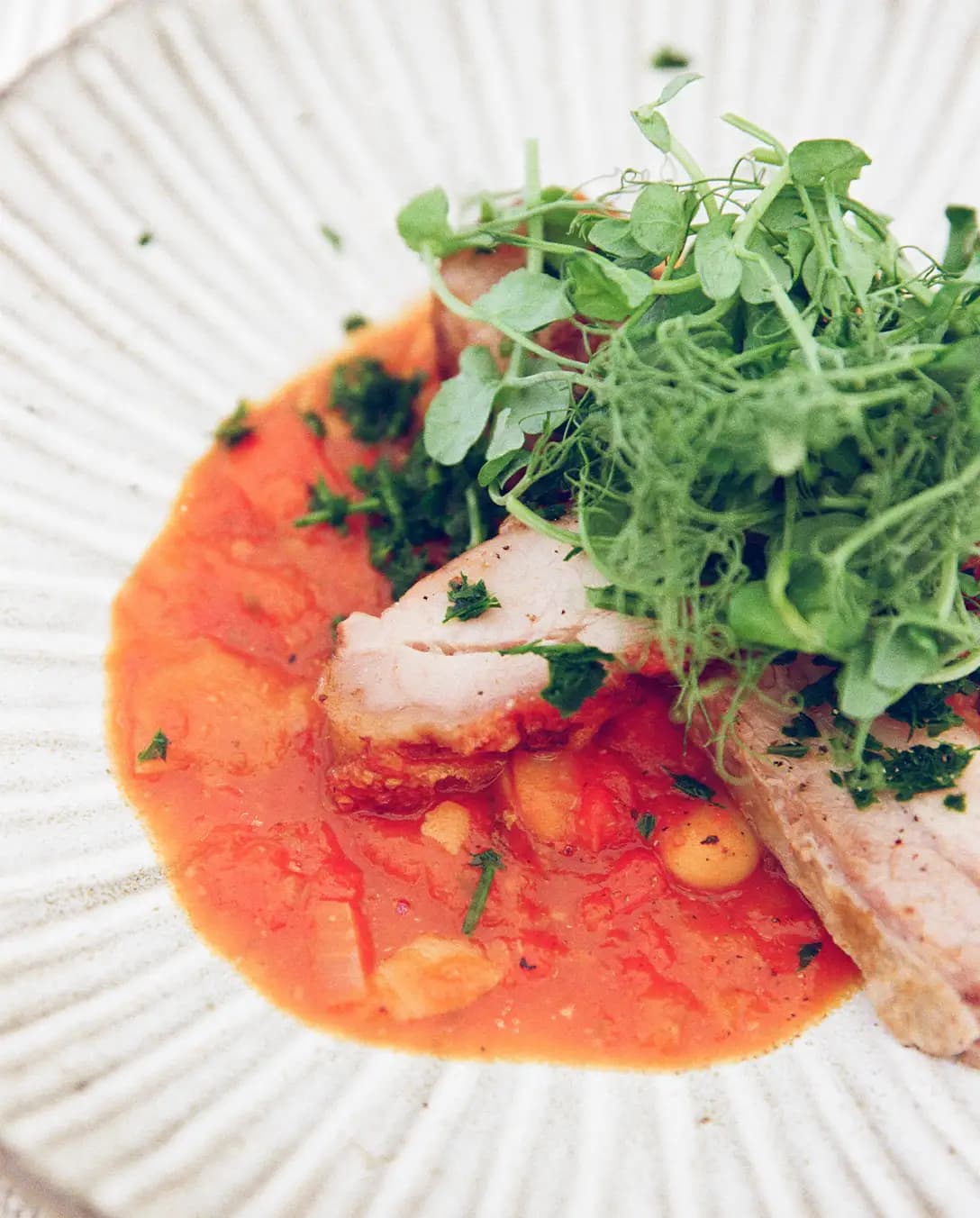 A wedding catering platter with a pork belly main garnished with watercress