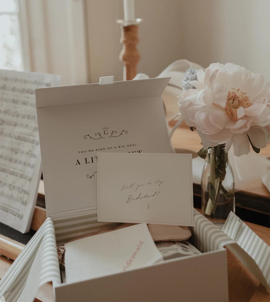 Beautifully styled open gift box with personalised envelope and presents for future bridesmaids.