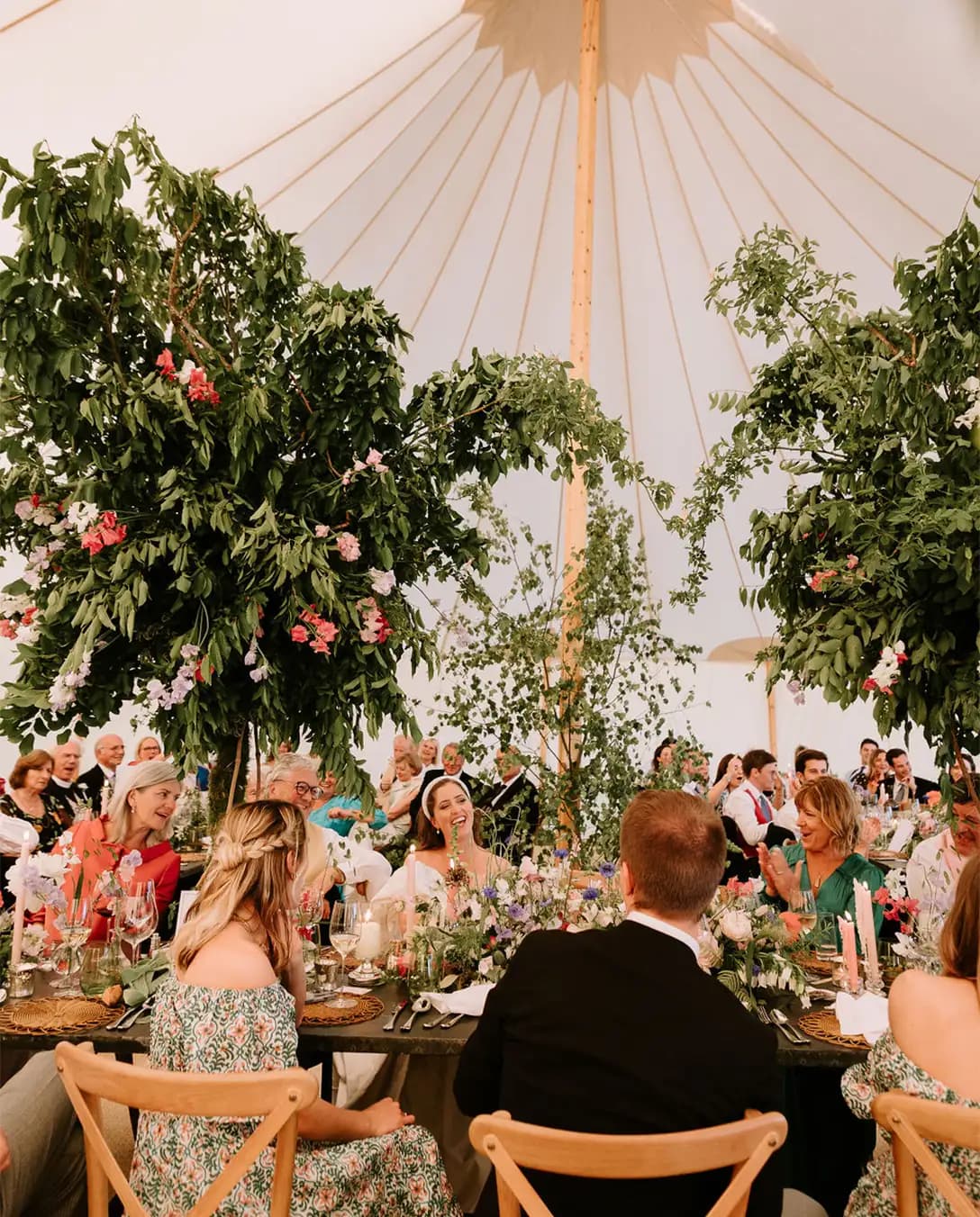 Guests and newlyweds sitting in a marquee during their wedding dinner