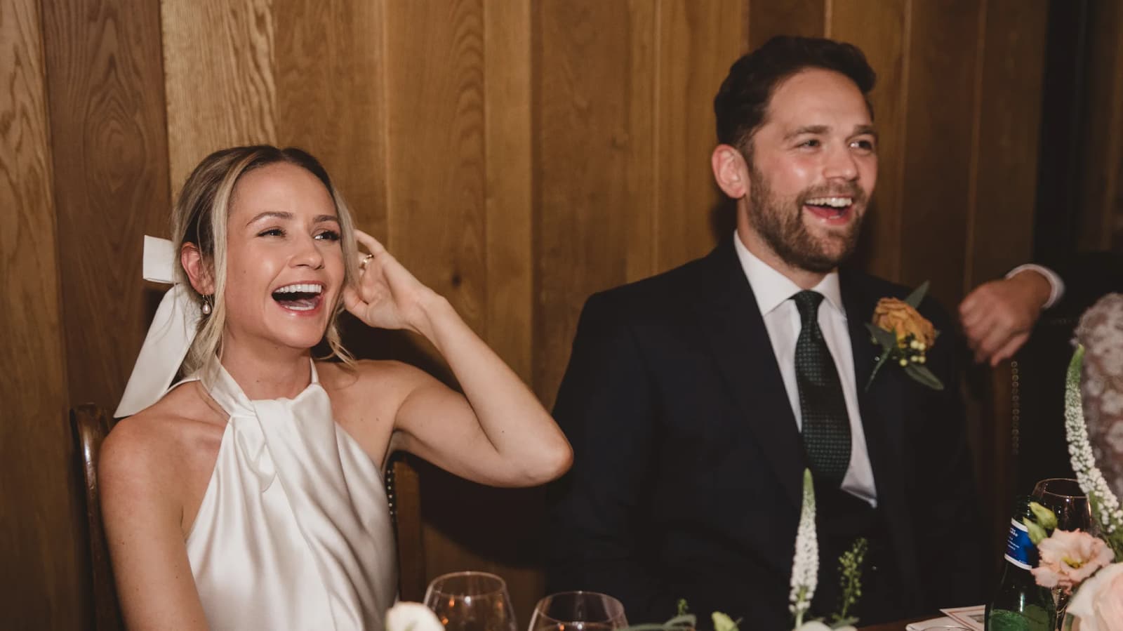 Bride and groom laughing together during their wedding meal
