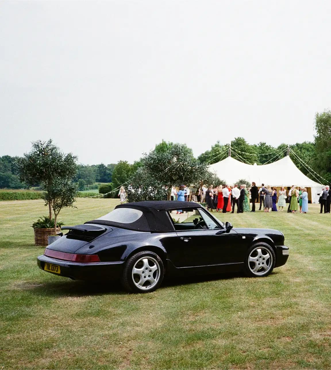 vintage black convertible car parked outside the marquee at a Hampshire wedding
