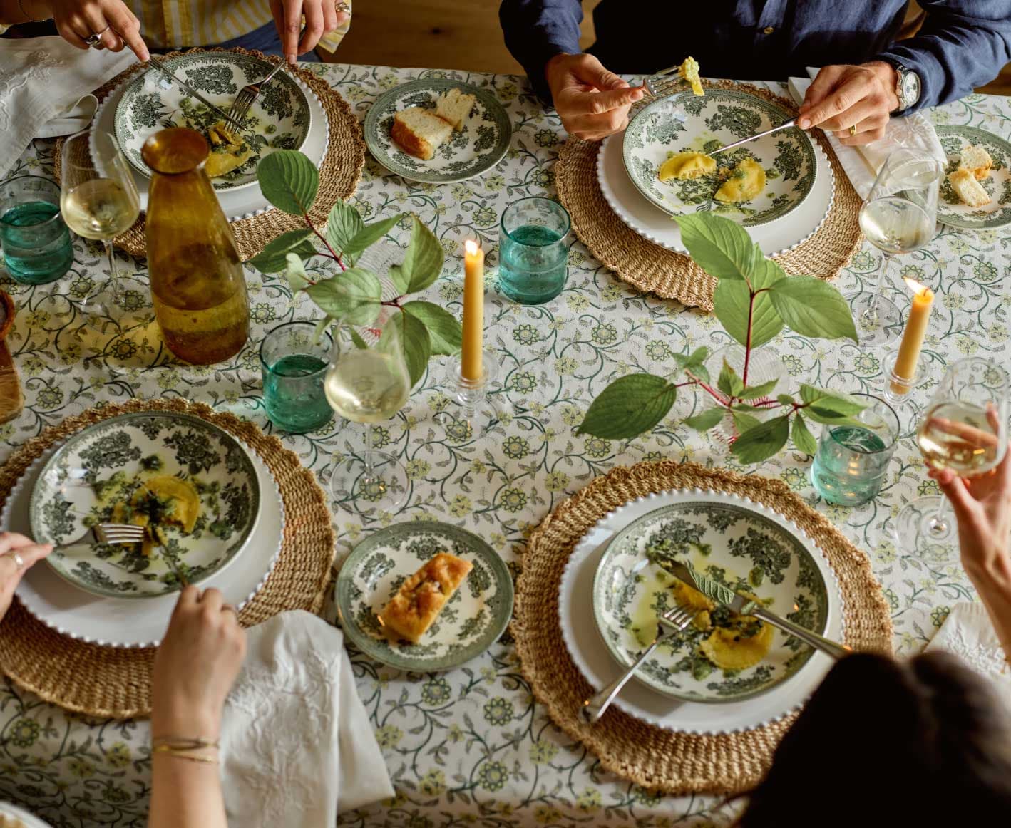 Table setting of friends eating pasta and drinking wine