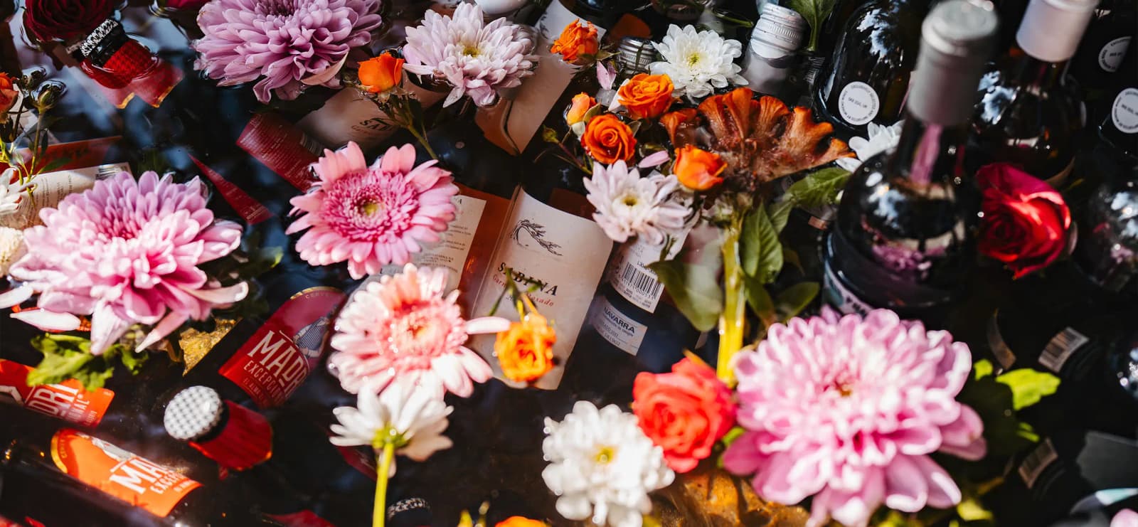 Wine bottles are hidden among colourful flowers