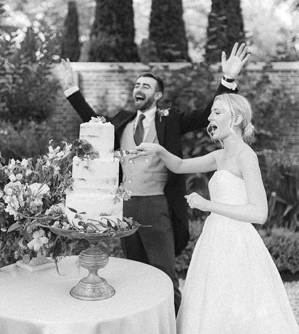 Bride & Groom cut tiered, buttercream wedding cake with flowers