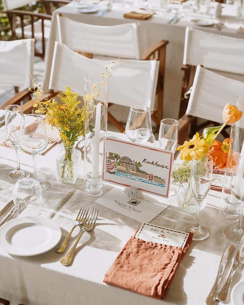 A beach themed custom wedding seating sign placed on a sun-lit wedding table