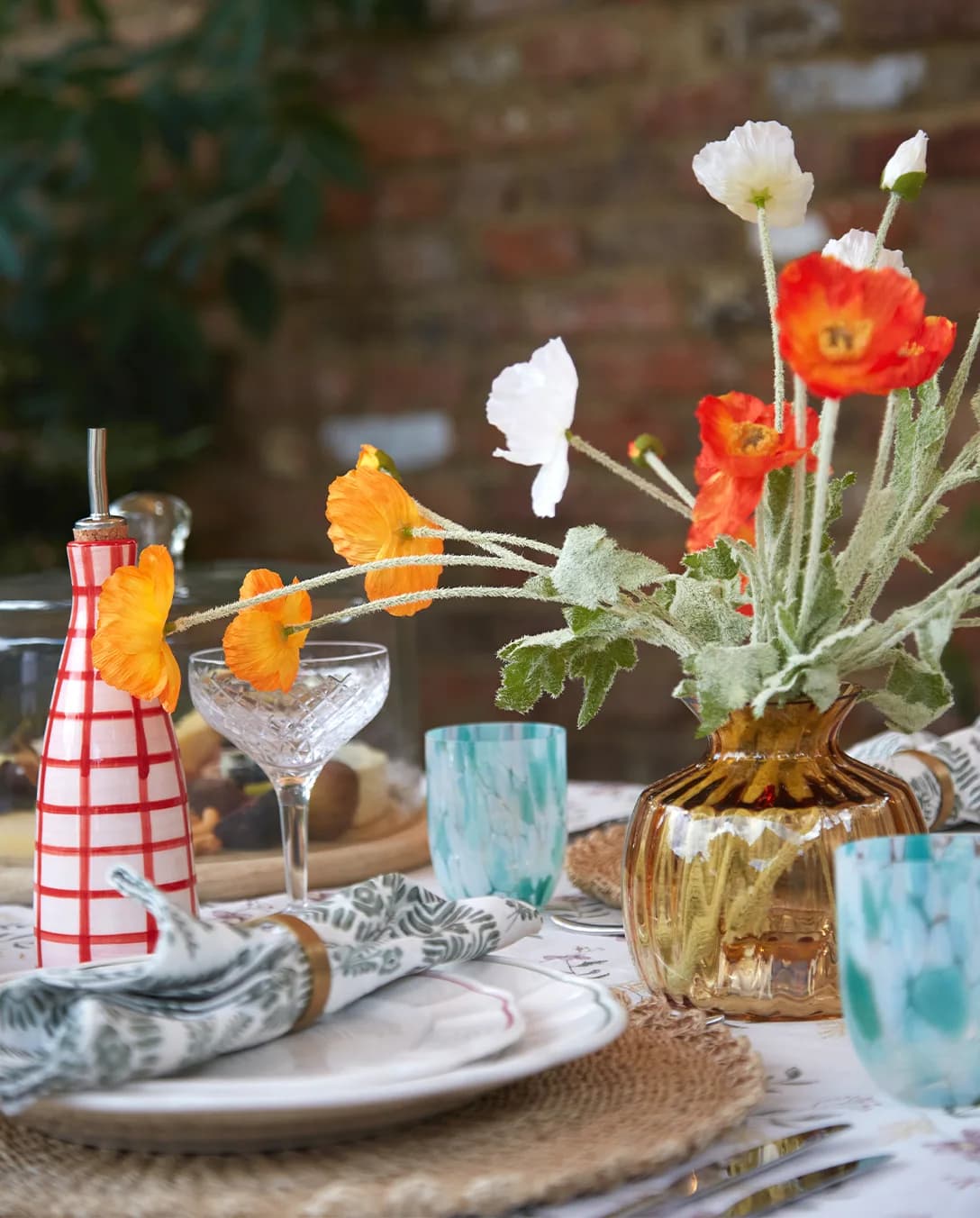 Summer tablescape with red poppies features luxury tableware & glassware wedding presents including a colourful glasses and red oil dispenser.