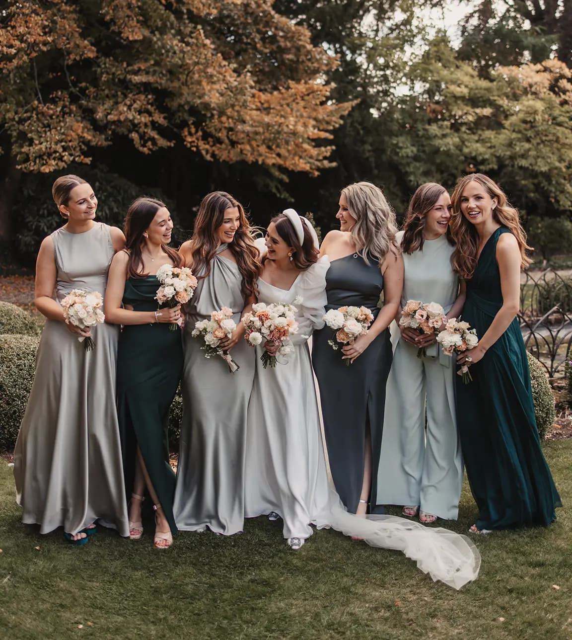 Bride pose with her bridesmaids in matching green dresses