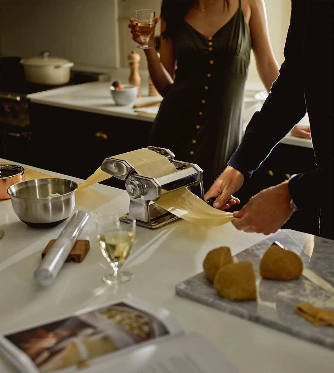Bride and groom make pasta while using their kitchenware wedding presents from The Wedding Present Company
