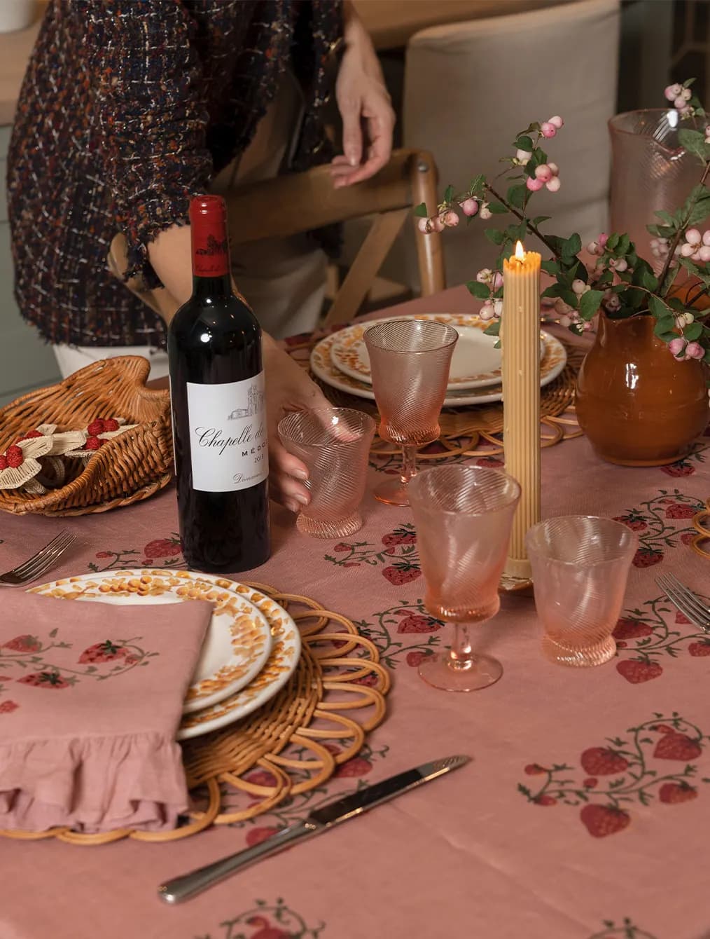 A person sets a cosy autumn tablescape with handpainted plates, pink glassware and candles from Sharland England & Wedding Present Companu