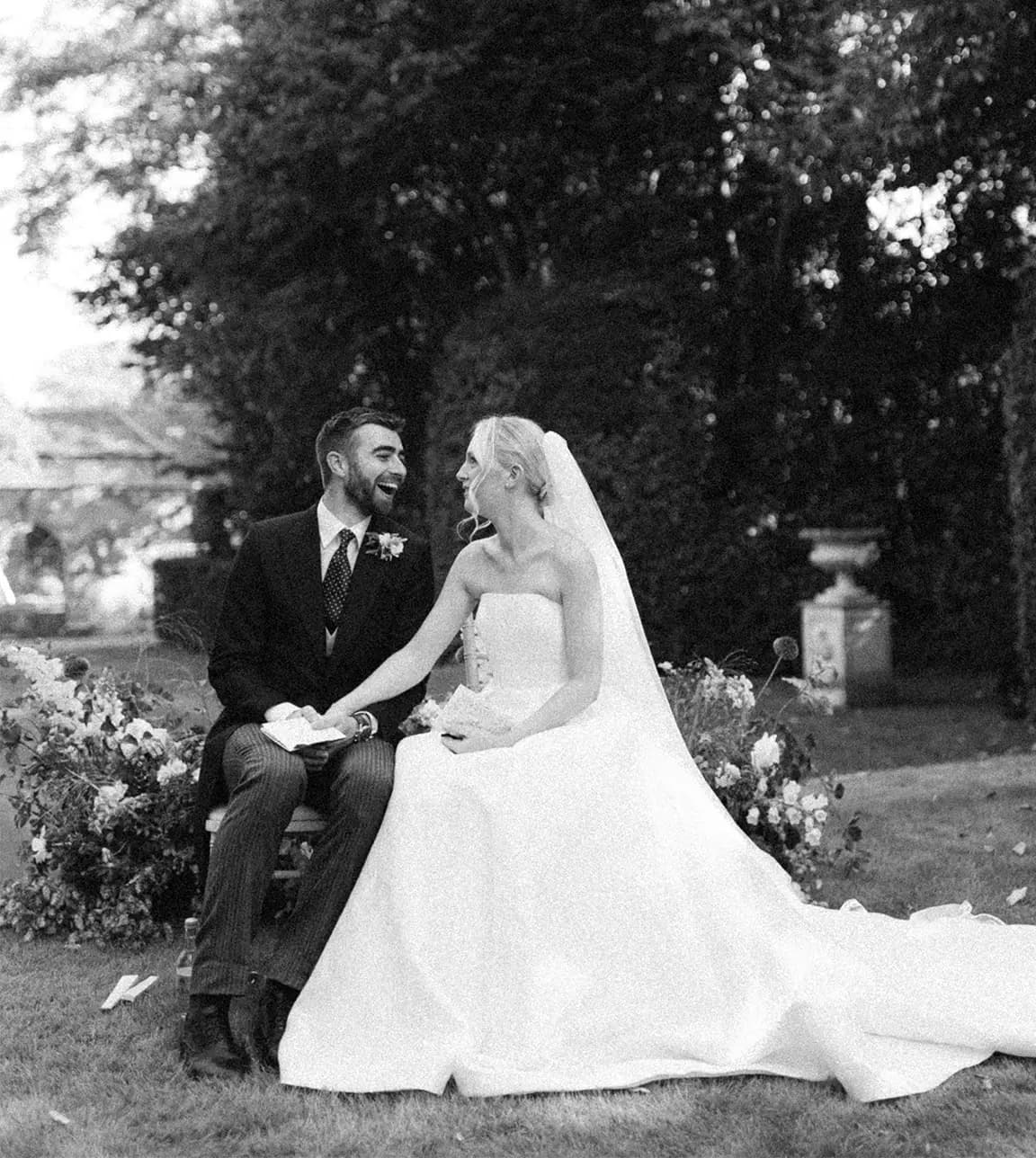 Groom and bride sit during their wedding ceremony while listening to wedding readings