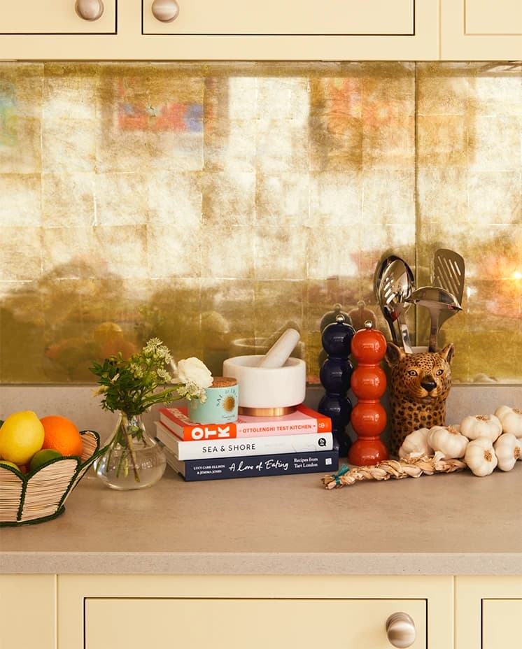 Rosalyn Wikeley's wedding presents on the kitchen counter: cookbooks, marble pestle & mortar and Addison Ross bobbin salt and pepper grinders in bright colours
