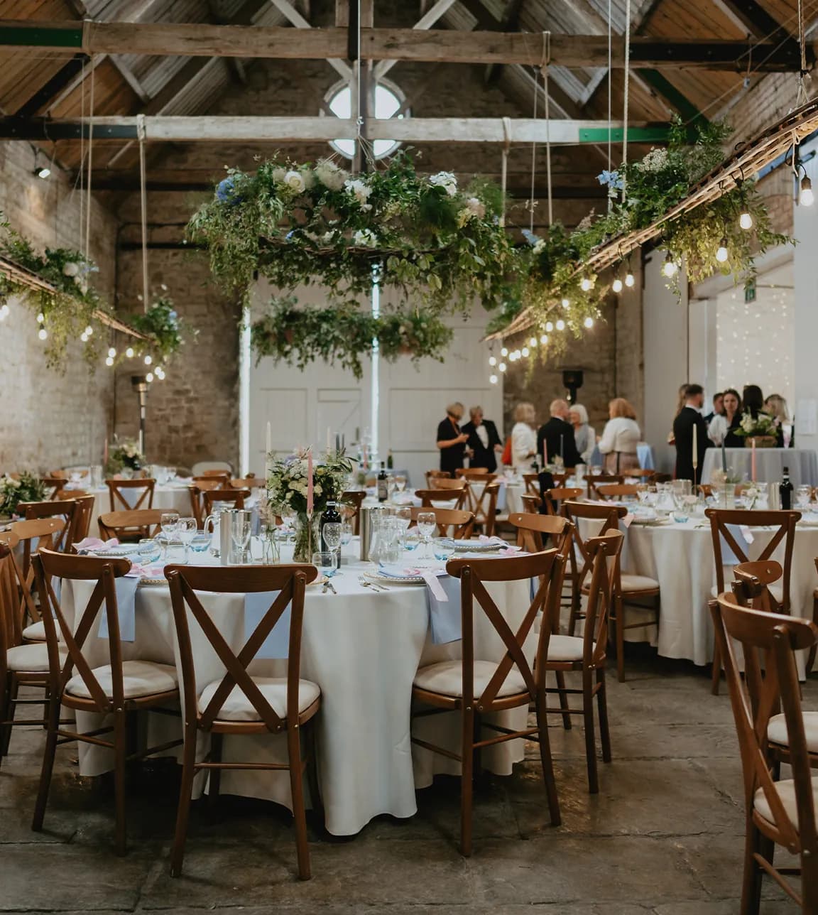 Wedding seating with round tables, beautifully arranged in a barn