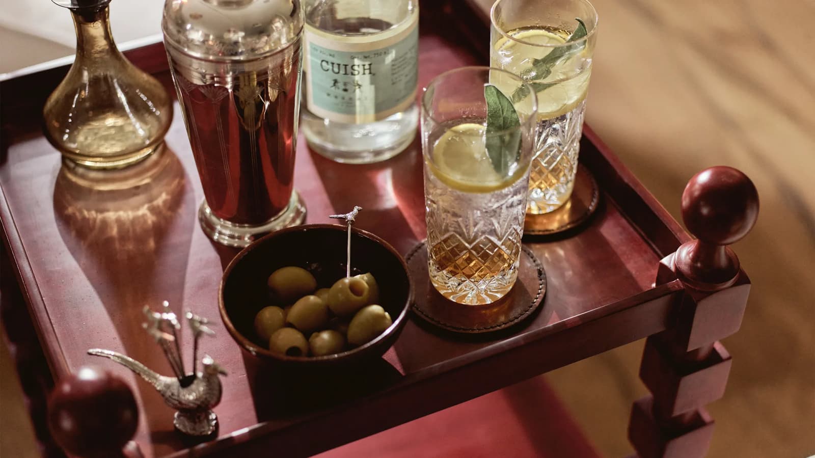 Oka red side table displays cocktail glasses and wedding presents for cocktail lovers.