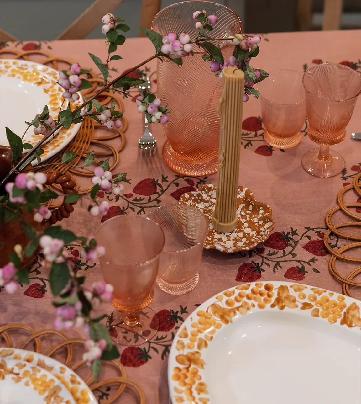 Coloured glassware, handpainted plates and platter from Sharland England on a table in The Wedding Present Company showroom