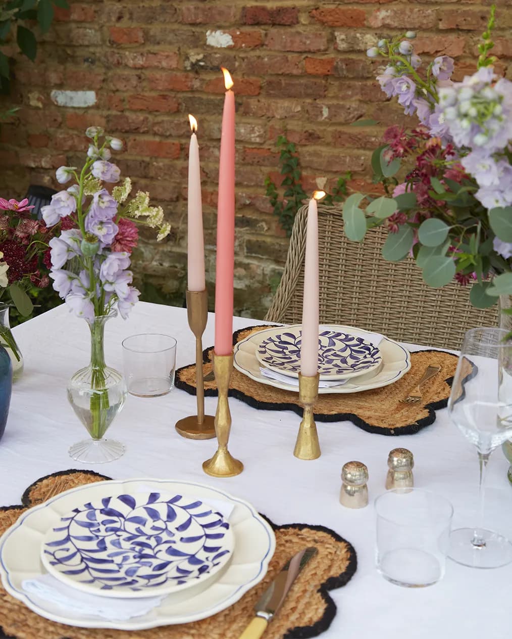 Purple & blue tablescape features tableware wedding presents: brass candle holders, white tablecloth, handpainted plates