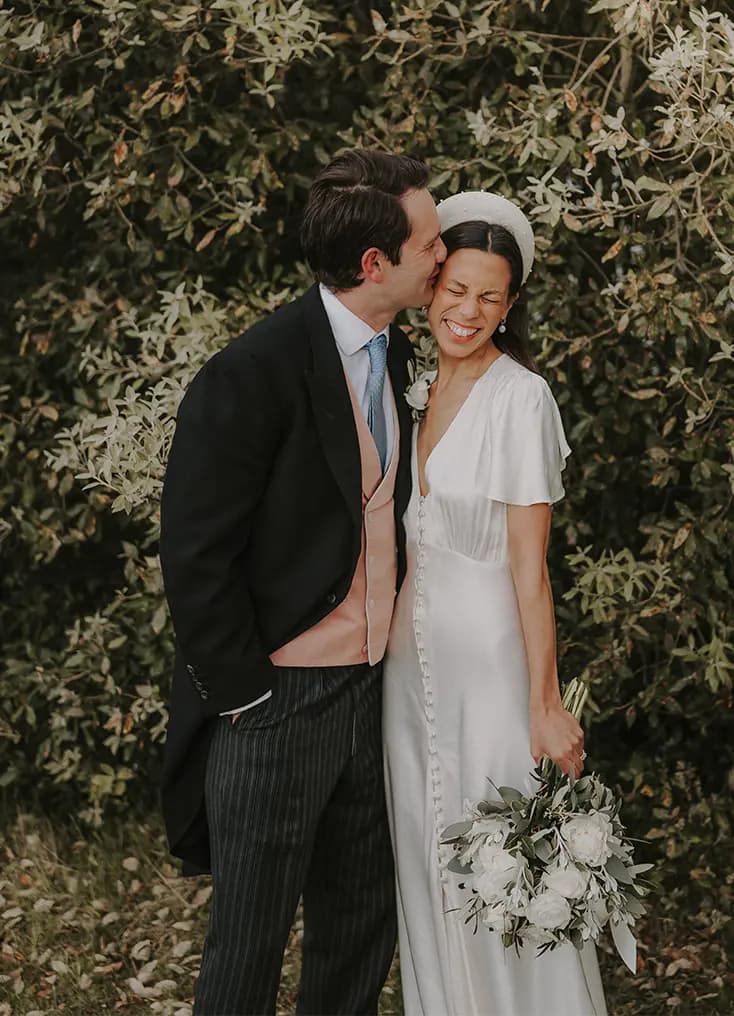 The Wedding Present Company groom kisses the bride during their Tuscany inspired wedding.
