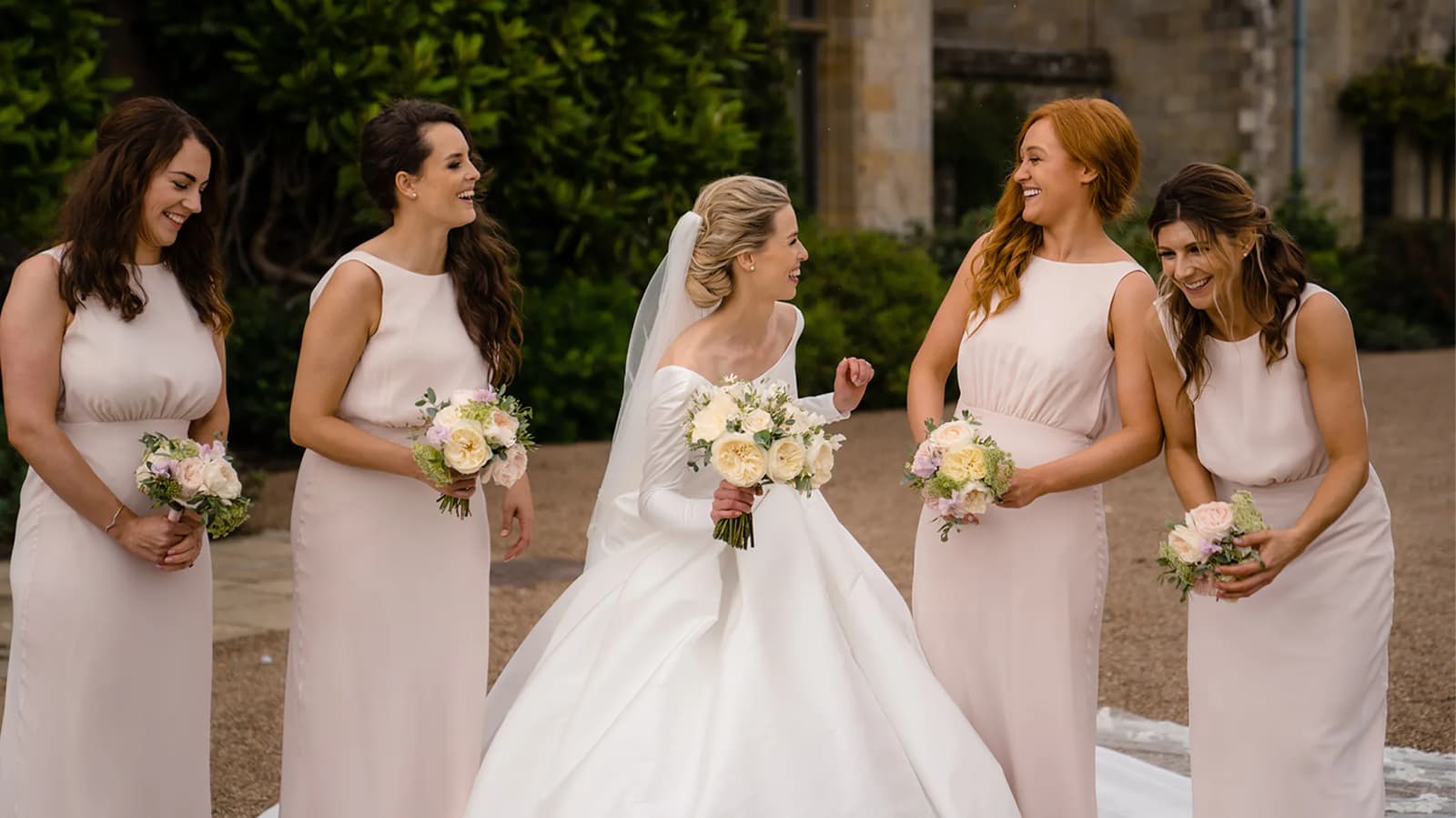bride and bridesmaids laughing together wedding