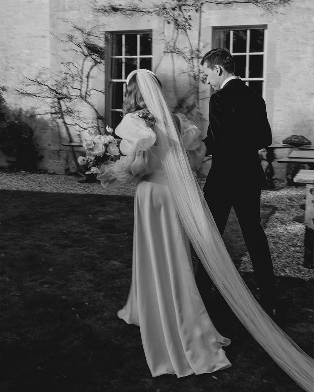 bride and groom walking from behind black and white romantic picture