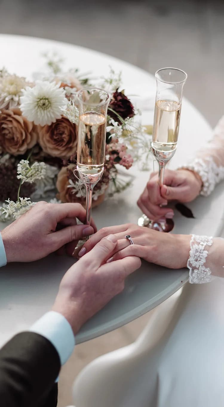 Bride and groom holding their hands and celebrating their wedding with champagne