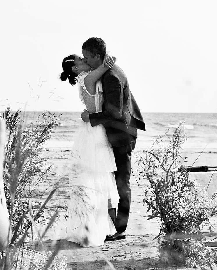 Laura Jackson kissing her husband during their beach wedding ceremony