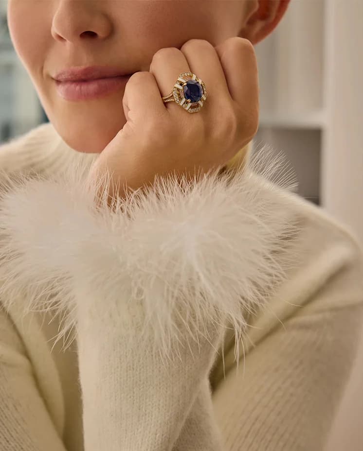 A woman wearing Boodles Fifth Avenue cushion sapphire yellow gold ring as her wedding jewellery