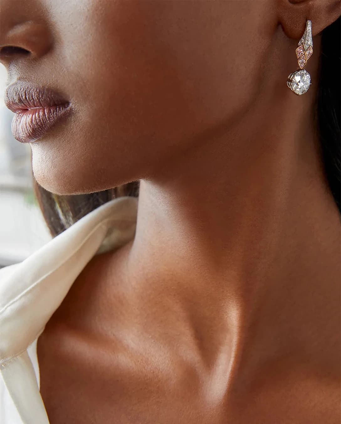 A woman wearing Boodles A Piece of Mined pink diamond drop earrings